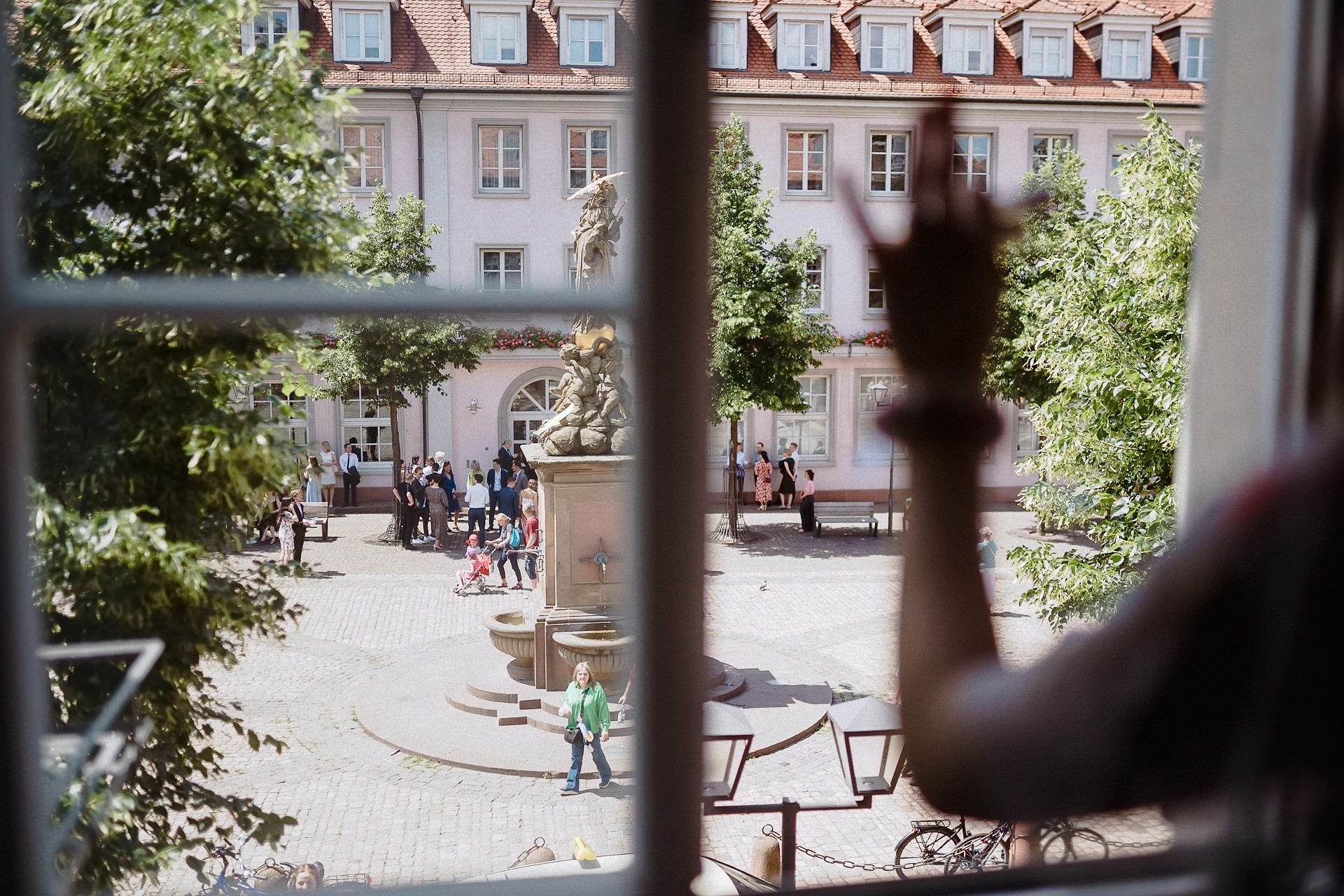 Freundin winkt aus dem Fenster um den Gästen vor dem Palais Prinz Carl hallo zu sagen