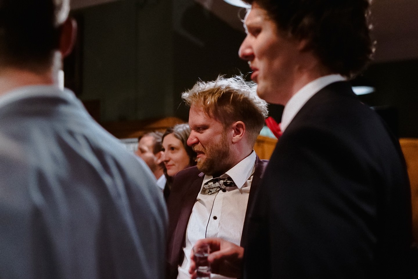 Gast auf der Hochzeit verzieht seinen Mund, weil er Schnaps getrunken hat