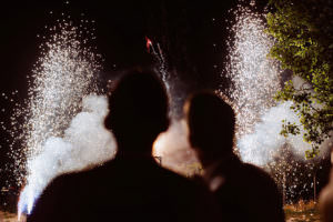 Beide Bräutigame schauen auf das Feuerwerk bei ihrer gleichgeschlechtlichen Hochzeit in der Pfalz