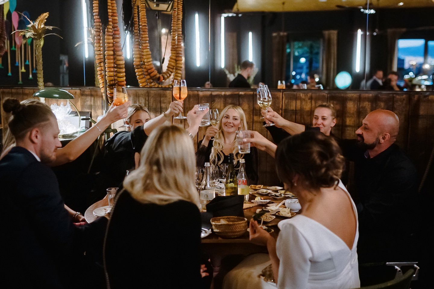 Braut stößt mit Gästen der Hochzeit an während des Dinners im Speicher 7